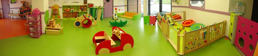 La photographie montre la salle de jeux, à dominante verts. Deux expaces distincts : un petit parc pour les bébés est inclus dans la salle des plus grands.